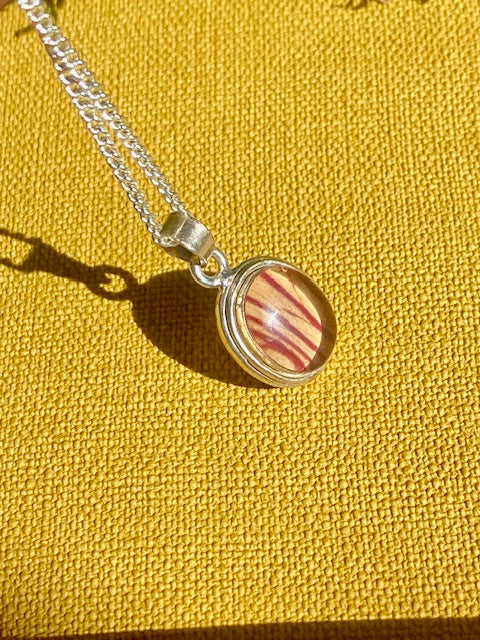 Exclusive silver oval pendant with trumpet flower.