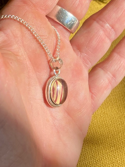 Exclusive silver oval pendant with trumpet flower.