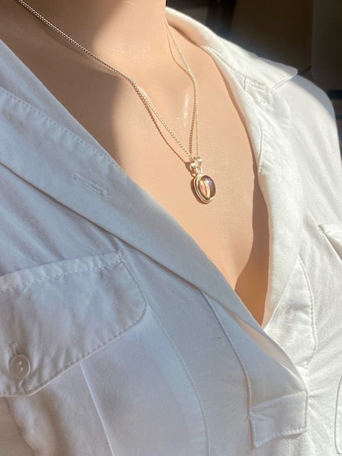 Exclusive silver oval pendant with trumpet flower.