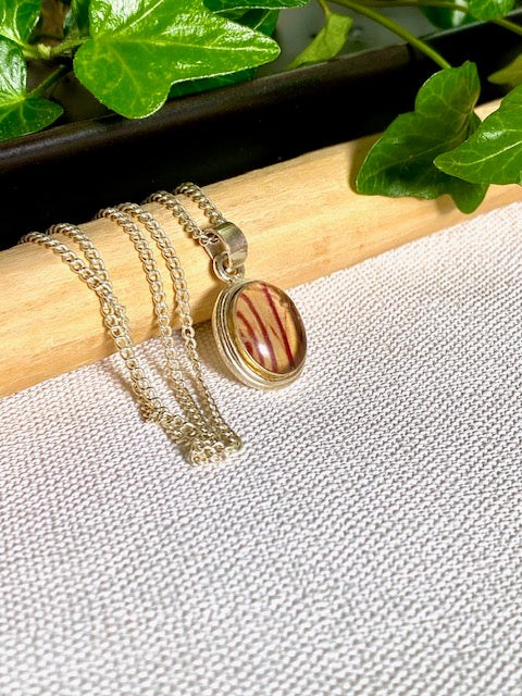 Exclusive silver oval pendant with trumpet flower.