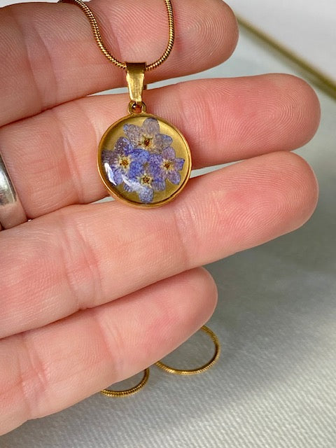 Gouden hanger met blauwe bloemetjes