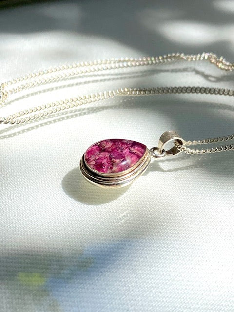 Exclusive silver drop pendant with pink flowers.