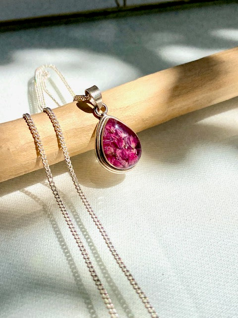 Exclusive silver drop pendant with pink flowers.