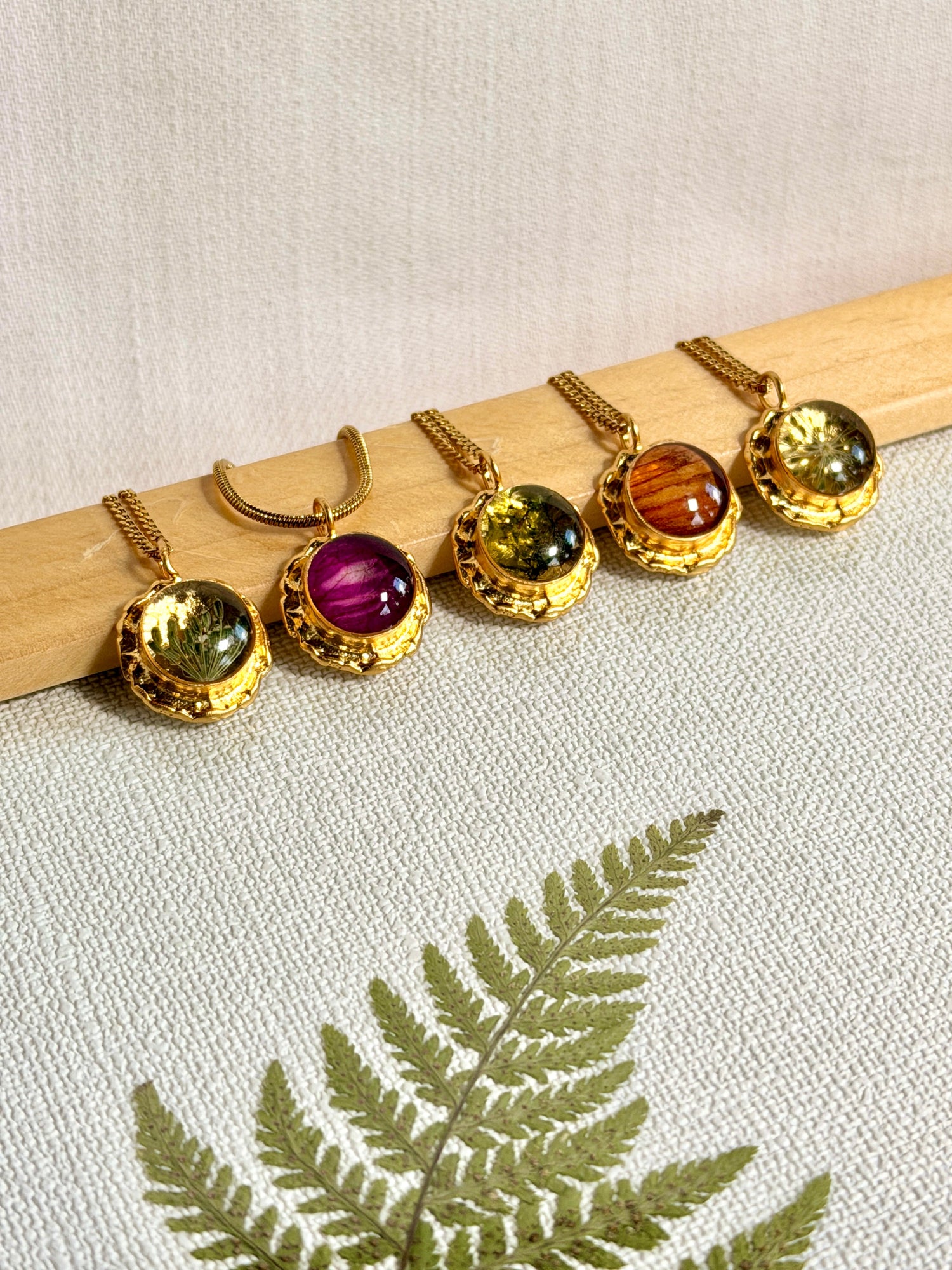 Vergulde hanger met roze bladpatroon – handgemaakt botanisch sieraad van BeLeaf Art, gedragen door model.