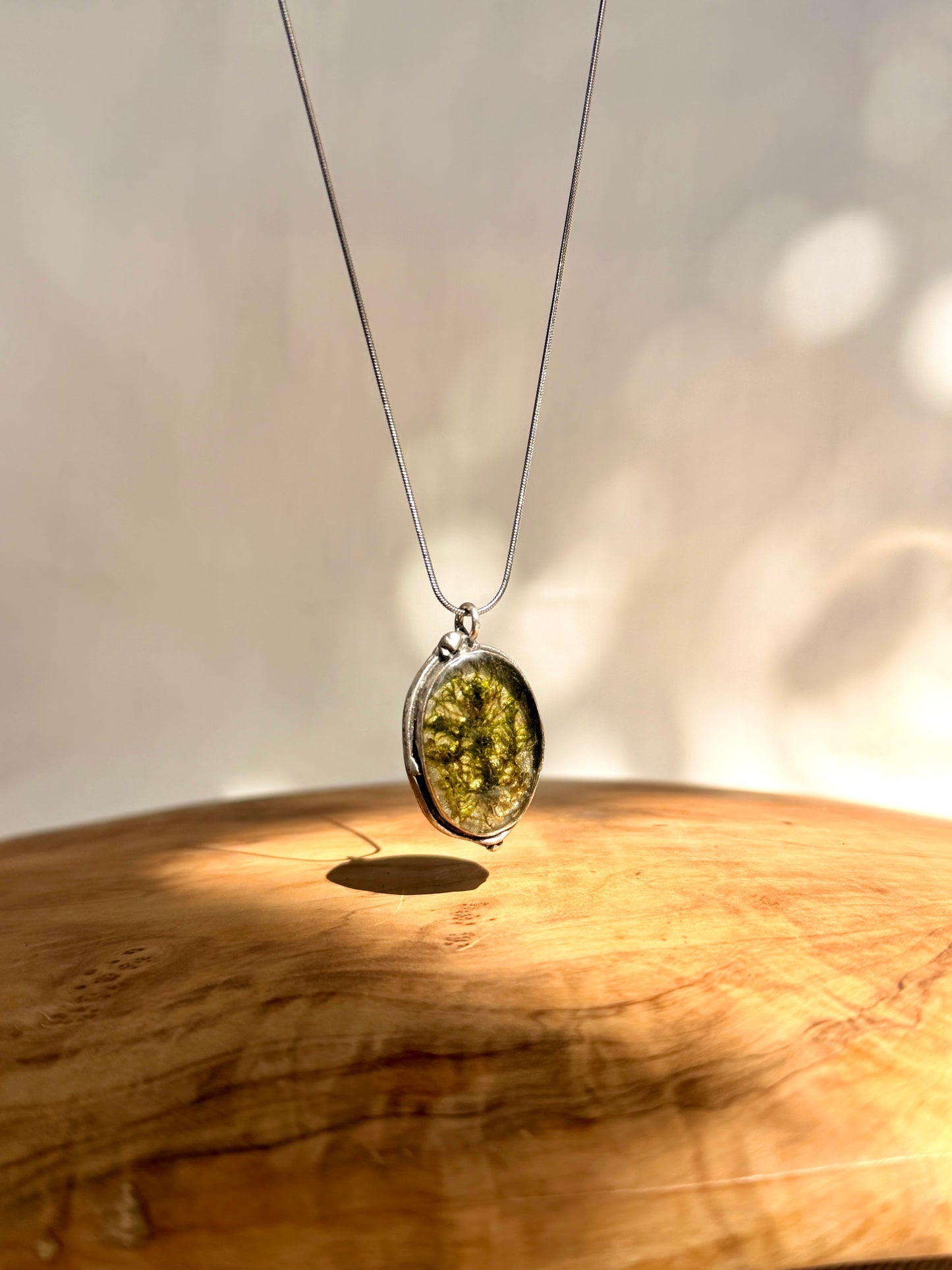 Silver-plated oval pendant (brass) with green moss.