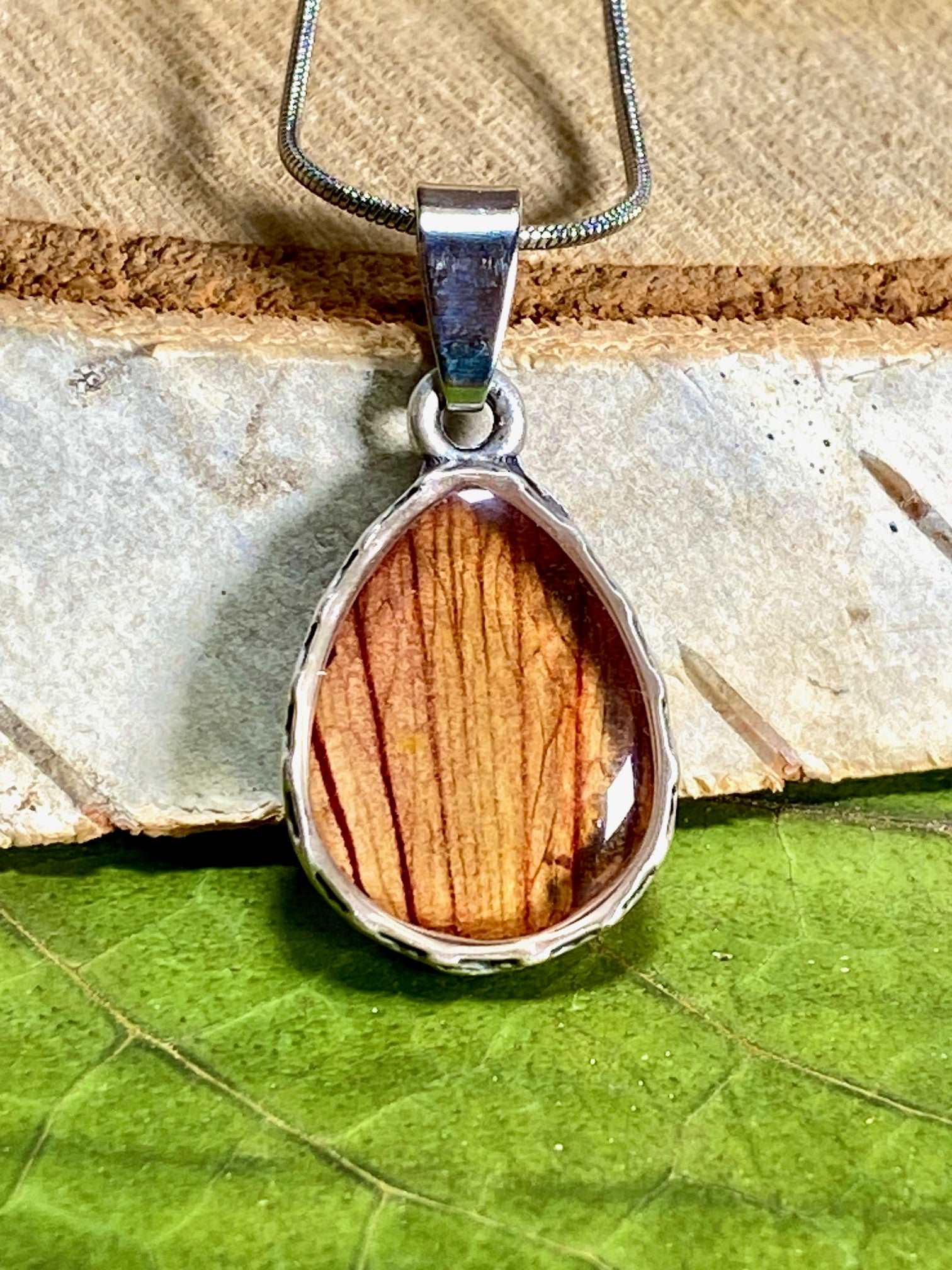 verzilverde druppel hanger met gestreept blad van de trompetbloem.