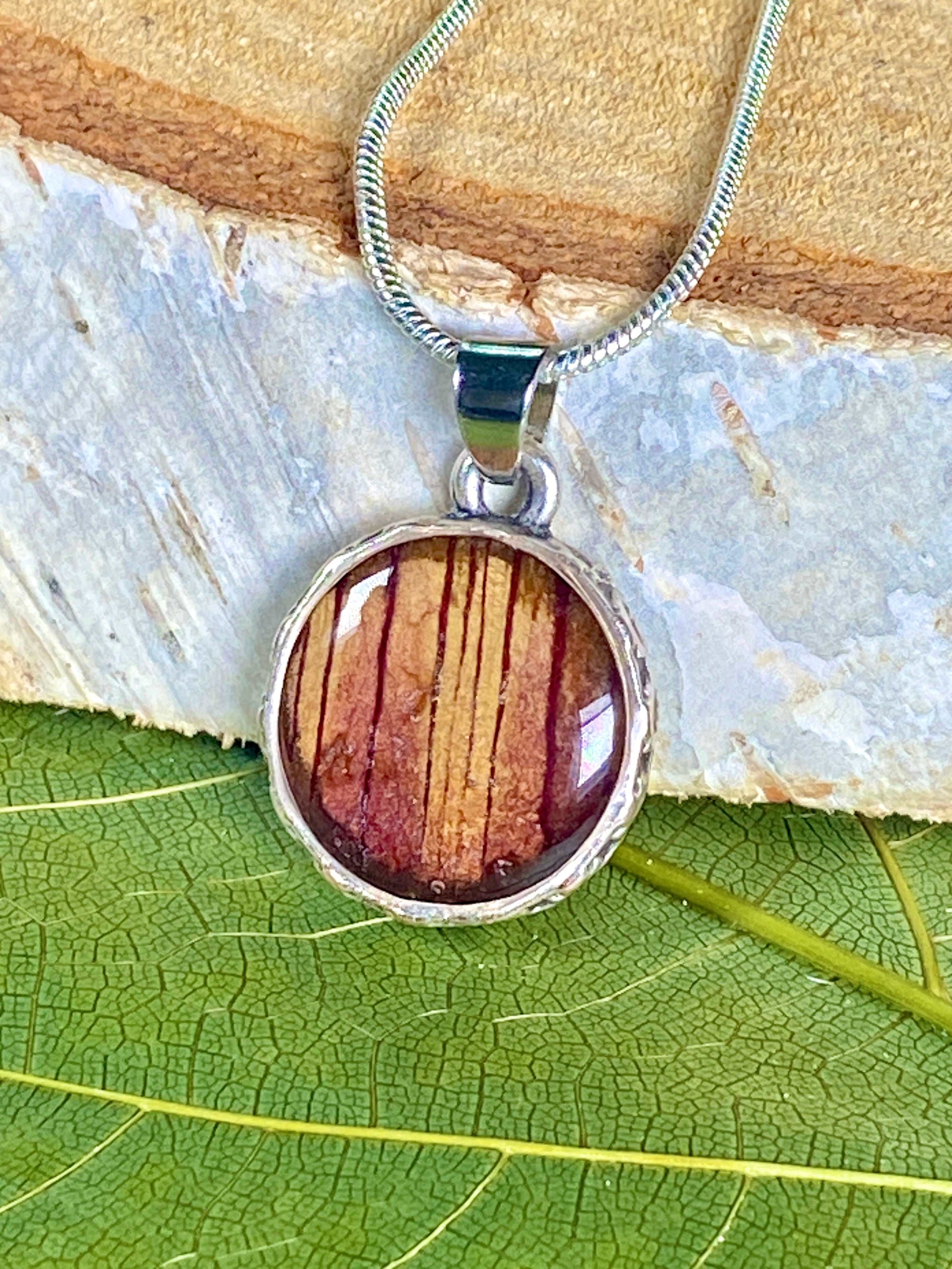 Verzilverde ronde hanger met rood-gele Trompetbloem.