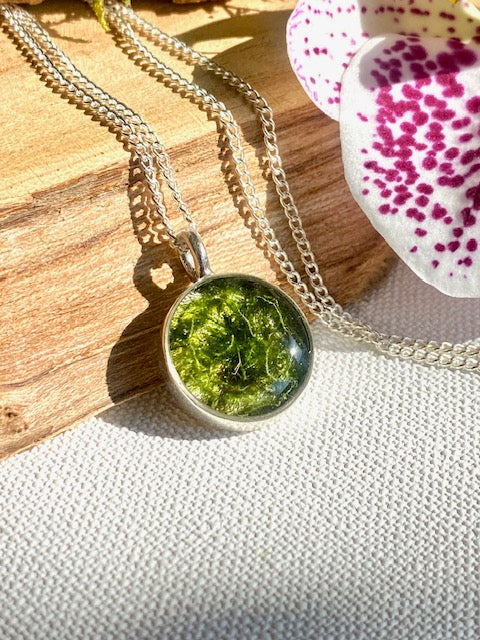 Beautiful silver-plated round pendant with moss.
