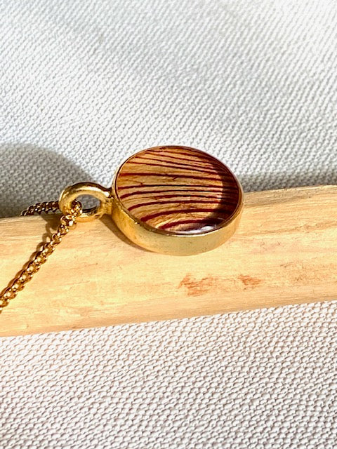 Vergulde hanger met prachtig detail van de trompetbloem.