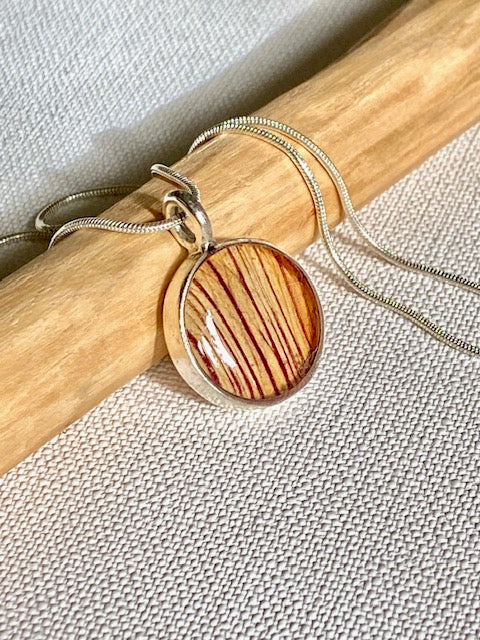 Zilveren hanger met gestreept detail van de trompetbloem.