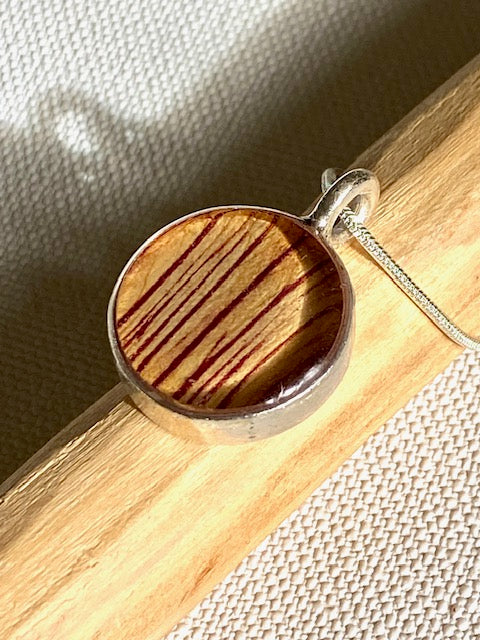 Zilveren hanger met gestreept detail van de trompetbloem.