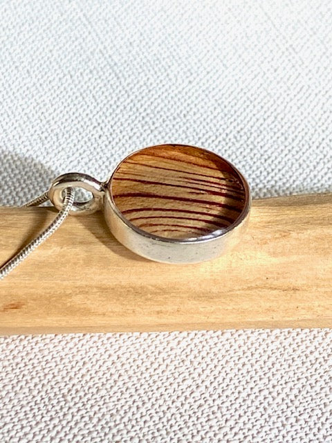Zilveren hanger met gestreept detail van de trompetbloem.