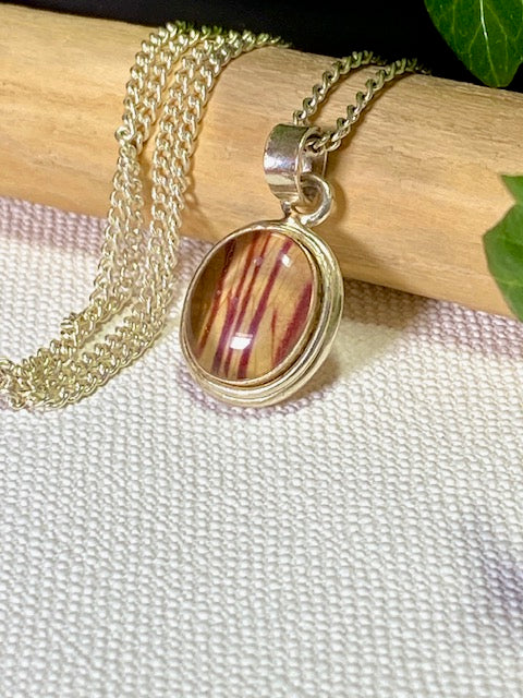 Exclusive silver oval pendant with trumpet flower.
