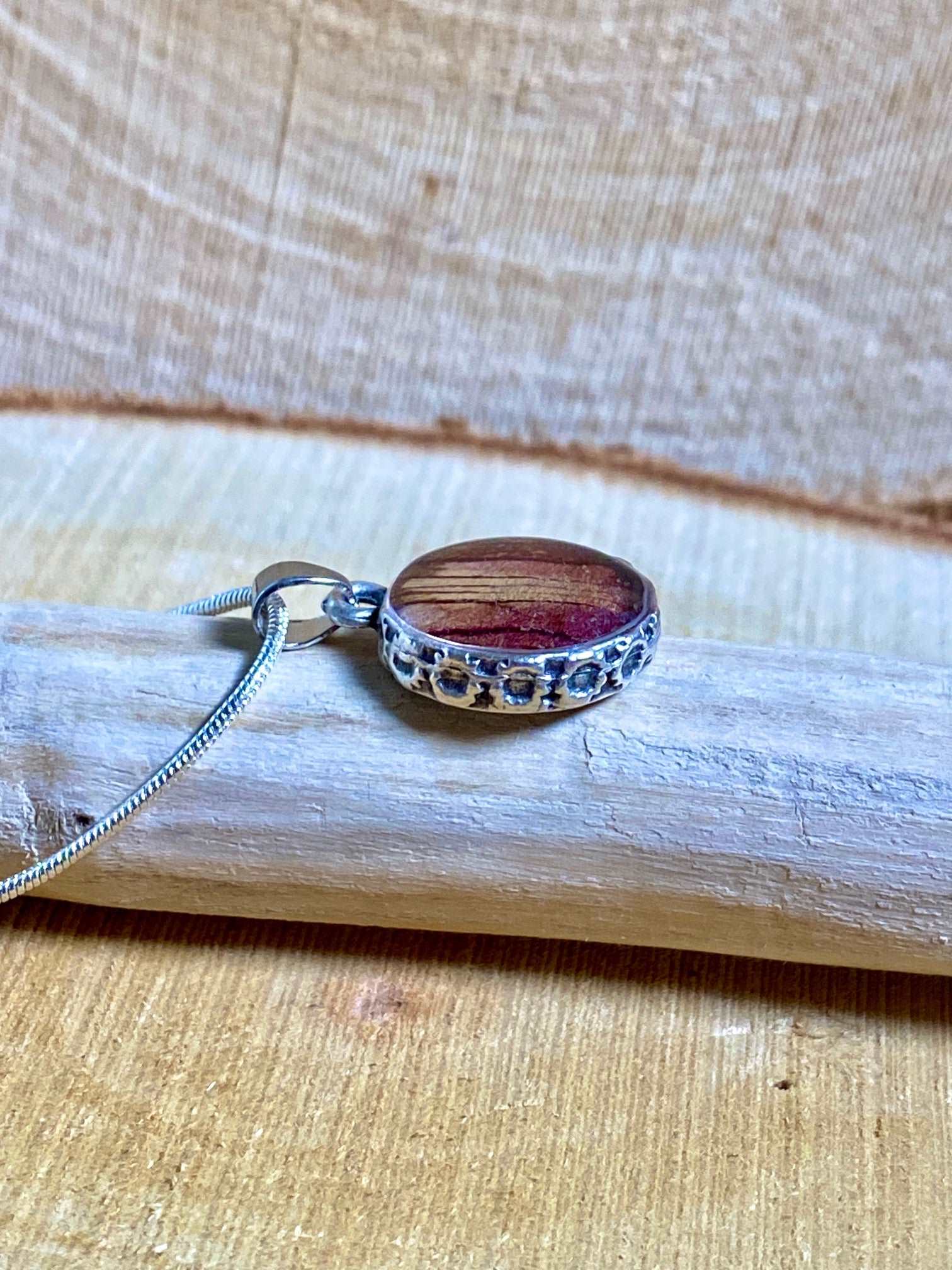 Verzilverde ronde hanger met rood-gele Trompetbloem.