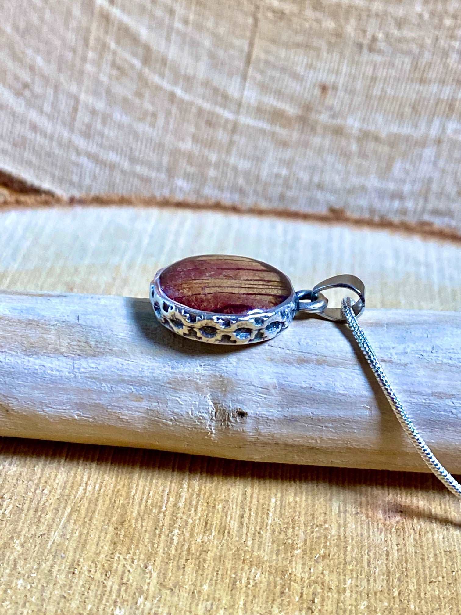 Verzilverde ronde hanger met rood-gele Trompetbloem.