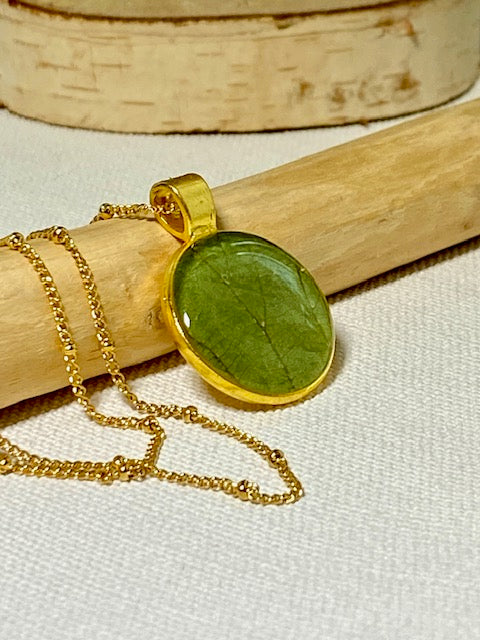 Handgemaakte ketting met groen blad in goudkleurige hanger