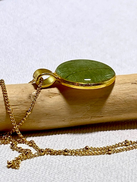 Handgemaakte ketting met groen blad in goudkleurige hanger