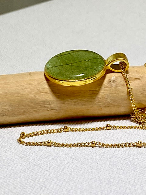 Handgemaakte ketting met groen blad in goudkleurige hanger