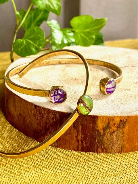 twee botanische vergulde armbanden met echte bloem en blad in kunsthars