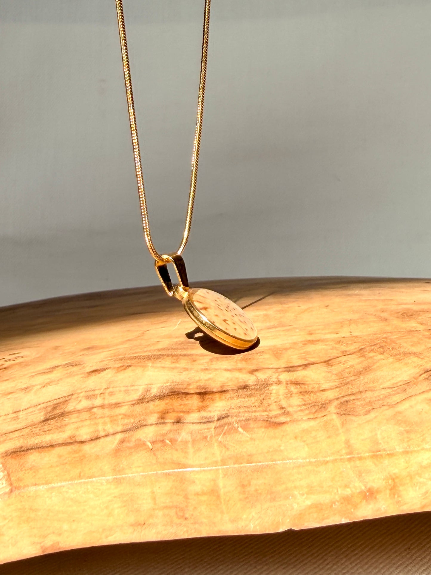 goudkleurige hanger met gebroken wit azaleablad met subtiele stipjes van BeLeaf Art