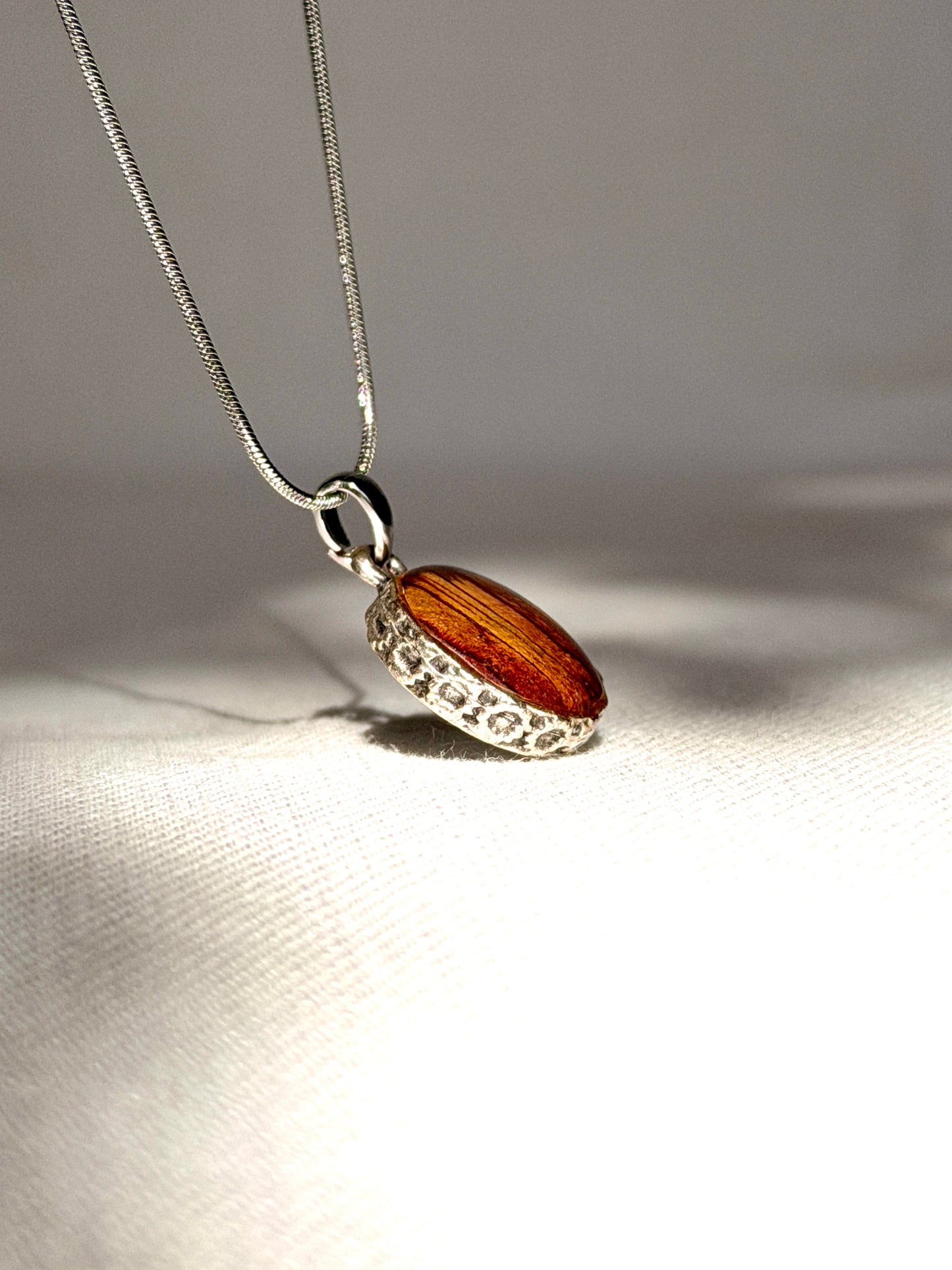 Verzilverde ronde hanger met rood-gele Trompetbloem.