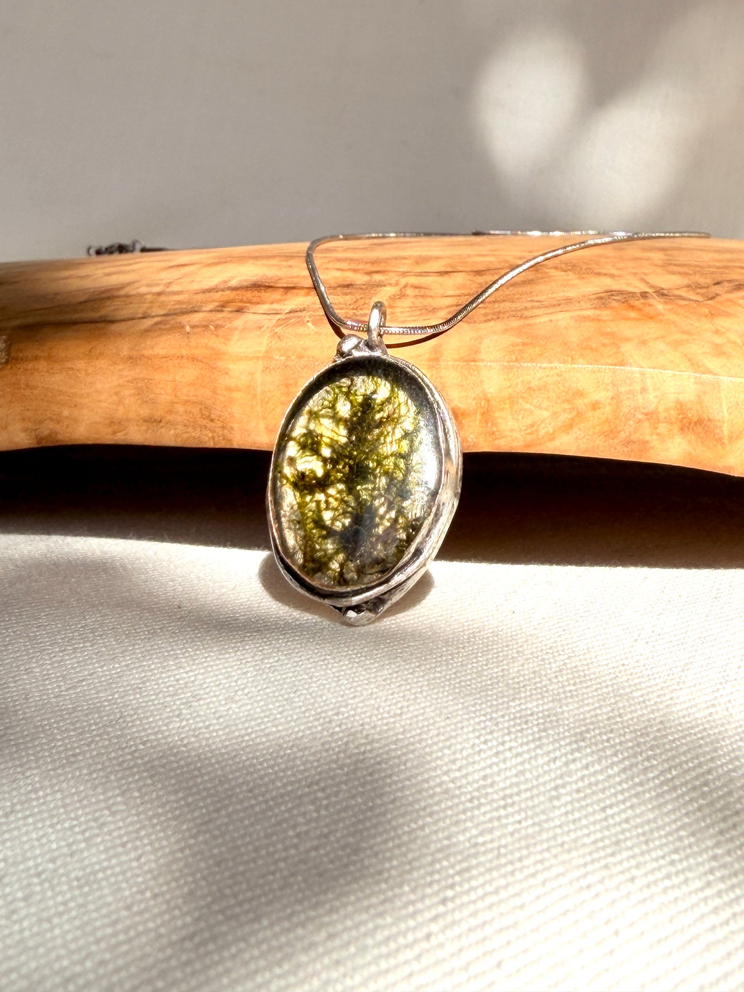Silver-plated oval pendant (brass) with green moss.