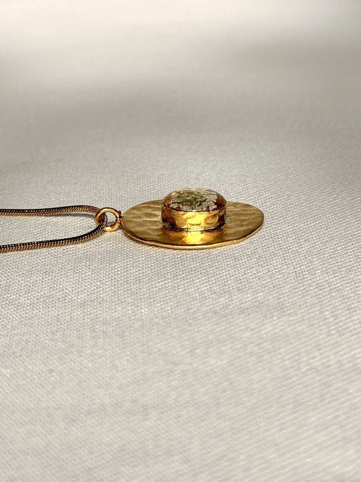Vergulde schermbloemhanger met zichtbare hoogte van de laagjes hars