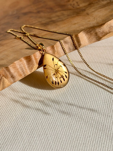 18k vergulde druppelhanger met karwijzaad in resin close up
