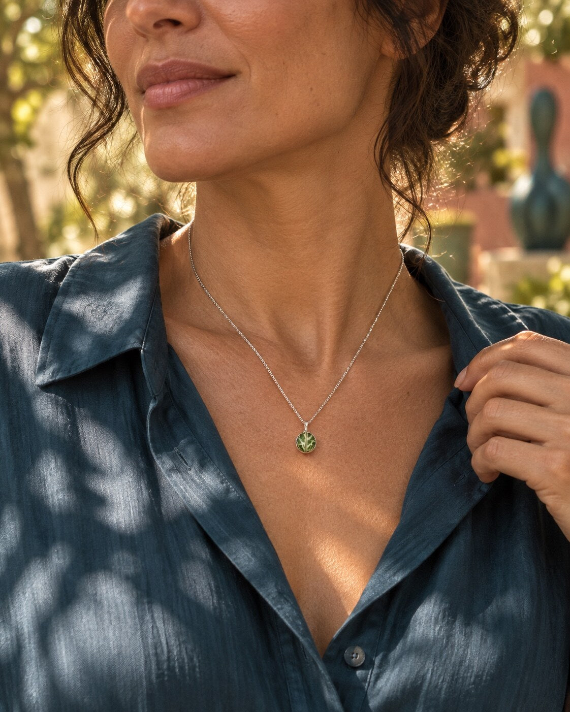 Verzilverde mini hanger met echt Fittonia-blad gedragen aan een zilveren ketting