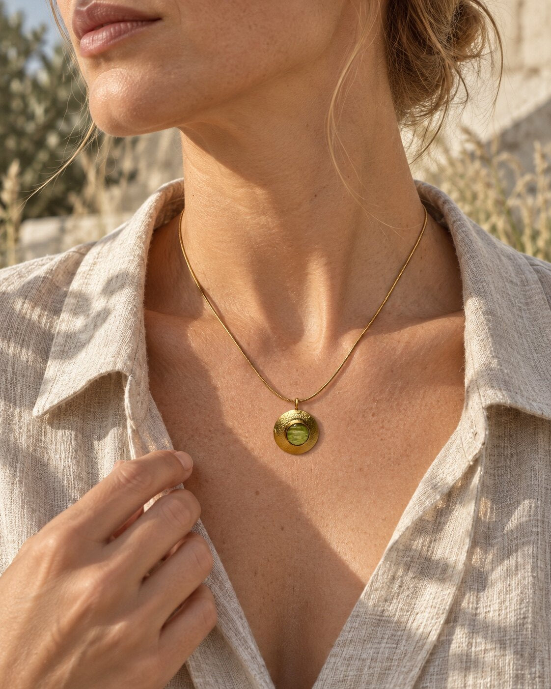 Model draagt een 22k vergulde hanger met echt varenblad aan een snakeketting