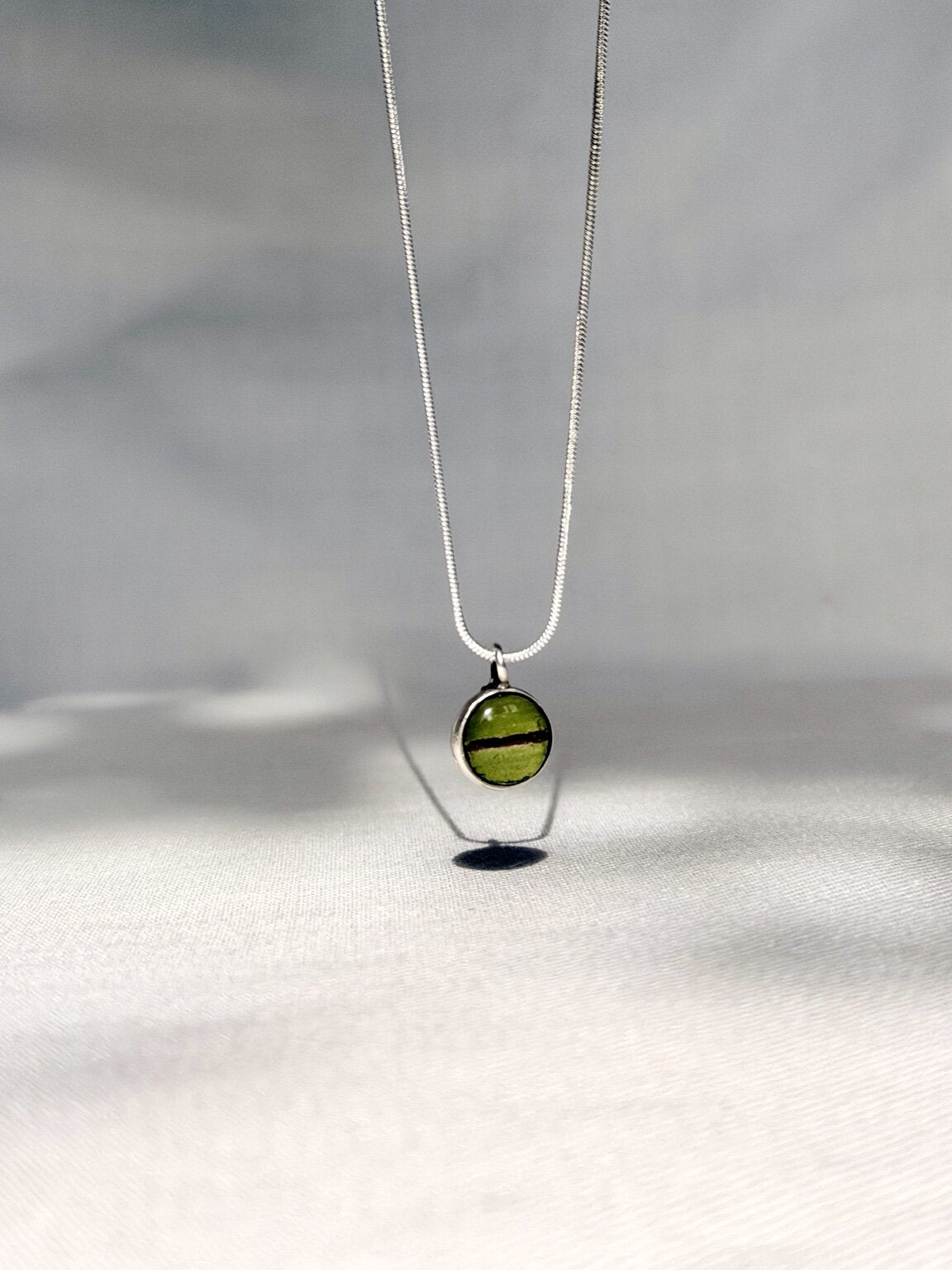 Handgemaakte mini hanger met groen varenblad en donkerbruine sporen