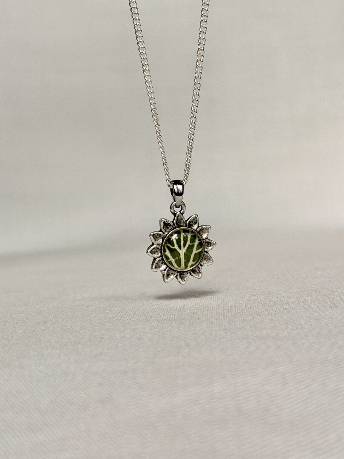 Zilverkleurige bloemhanger met mozaïekplant gedragen aan een 925 zilveren ketting