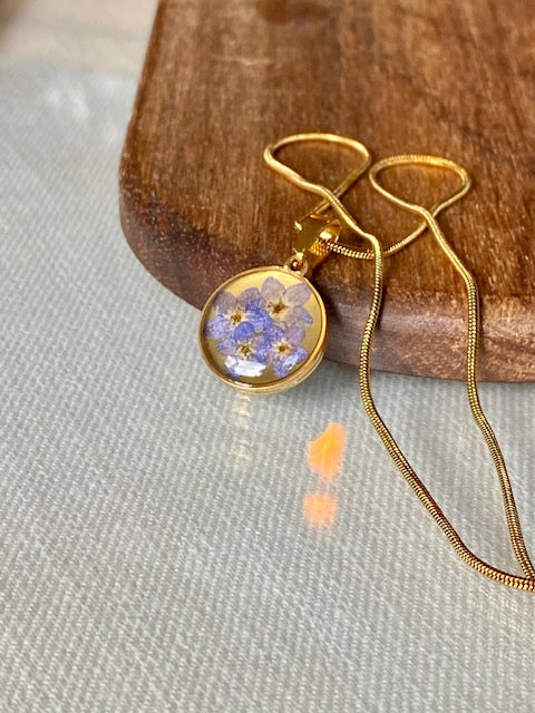 Gouden hanger met blauwe bloemetjes