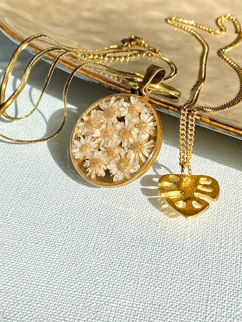 Madeliefjes in een grote ronde hanger, goldplated.