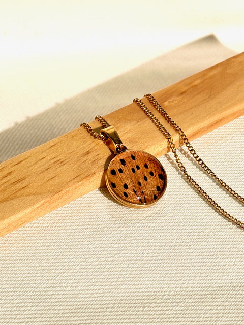 Unieke bloem hanger in goud met oranje en zwarte accenten van BeLeaf Art