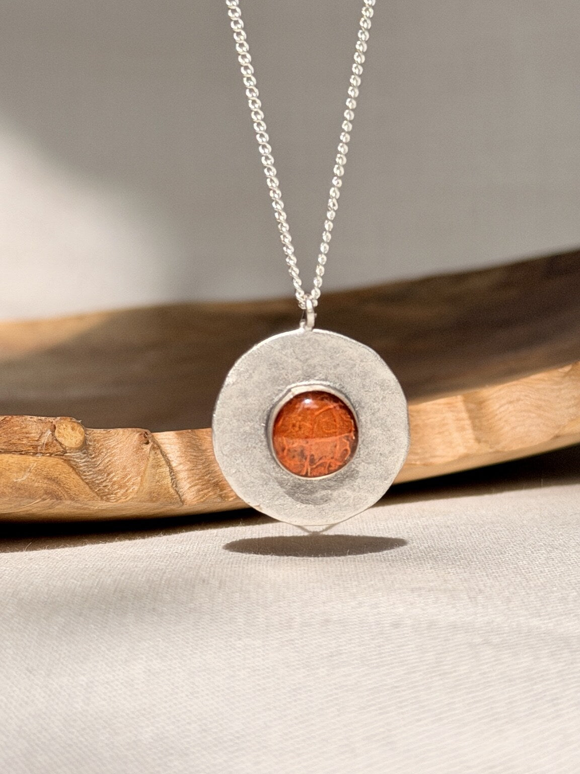 Verzilverde ronde hanger met oranje bloemblad - 25 mm