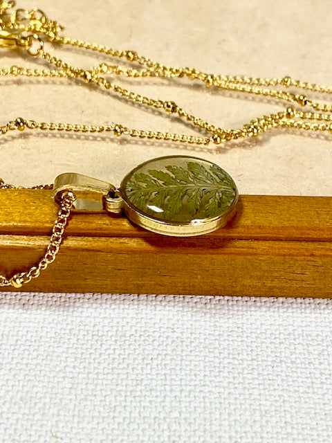 gold plated ronde hanger met blad van varen