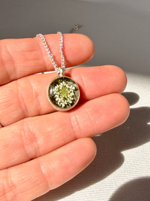 zilveren hanger rond met detail van witte schermbloem van BeLeaf Art