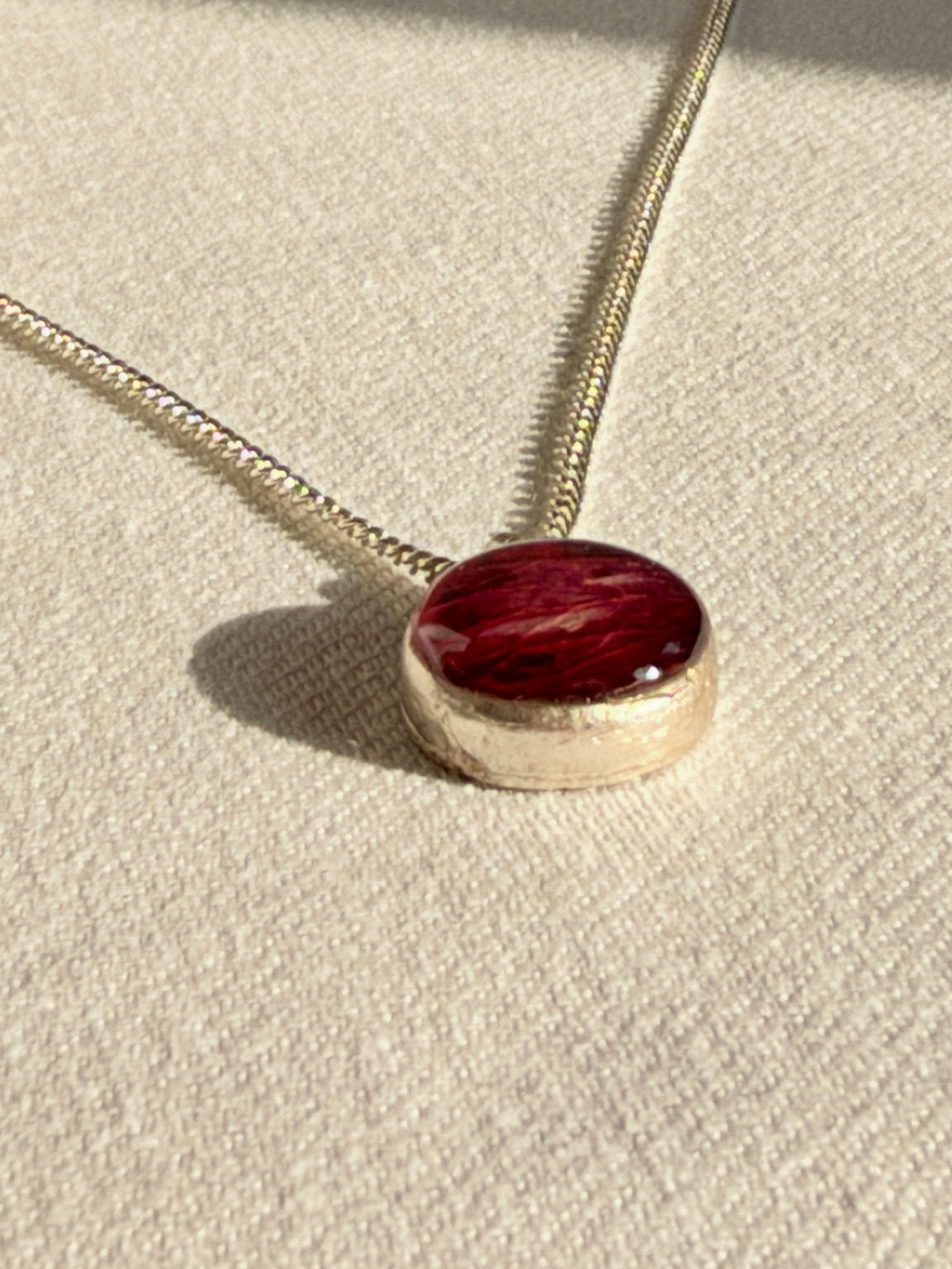 Zijaanzicht van de verzilverde hanger met ingelegd rozenblad
