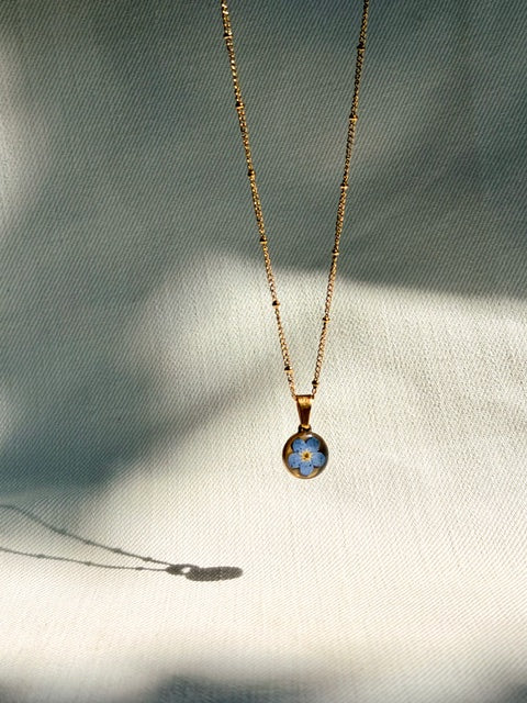 Goud hangertje met echt blauw vergeet-me-nietje in kleine ronde hanger BeLeaf Art
