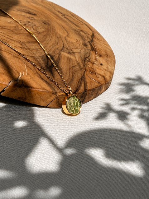 Kleine 22k vergulde hanger met groen fittonia blad en lichte nerven