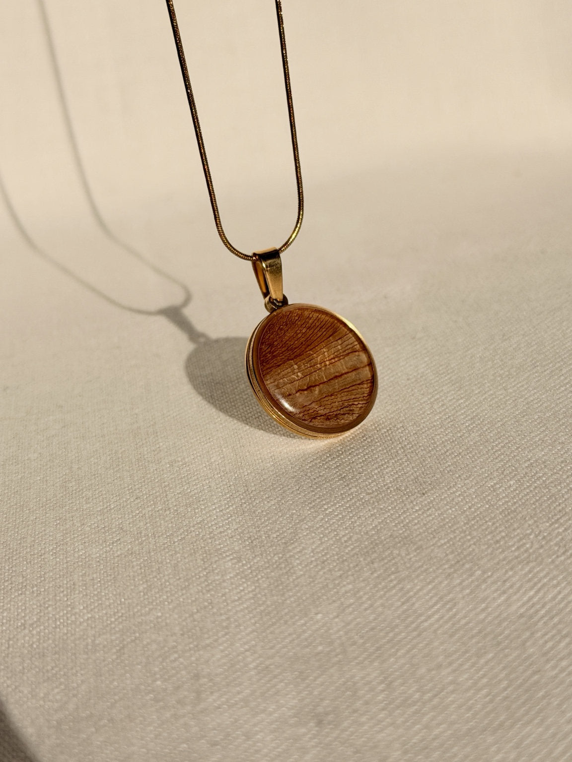 Handgemaakte hanger met gedroogd tulpenblad aan een goudkleurige ketting