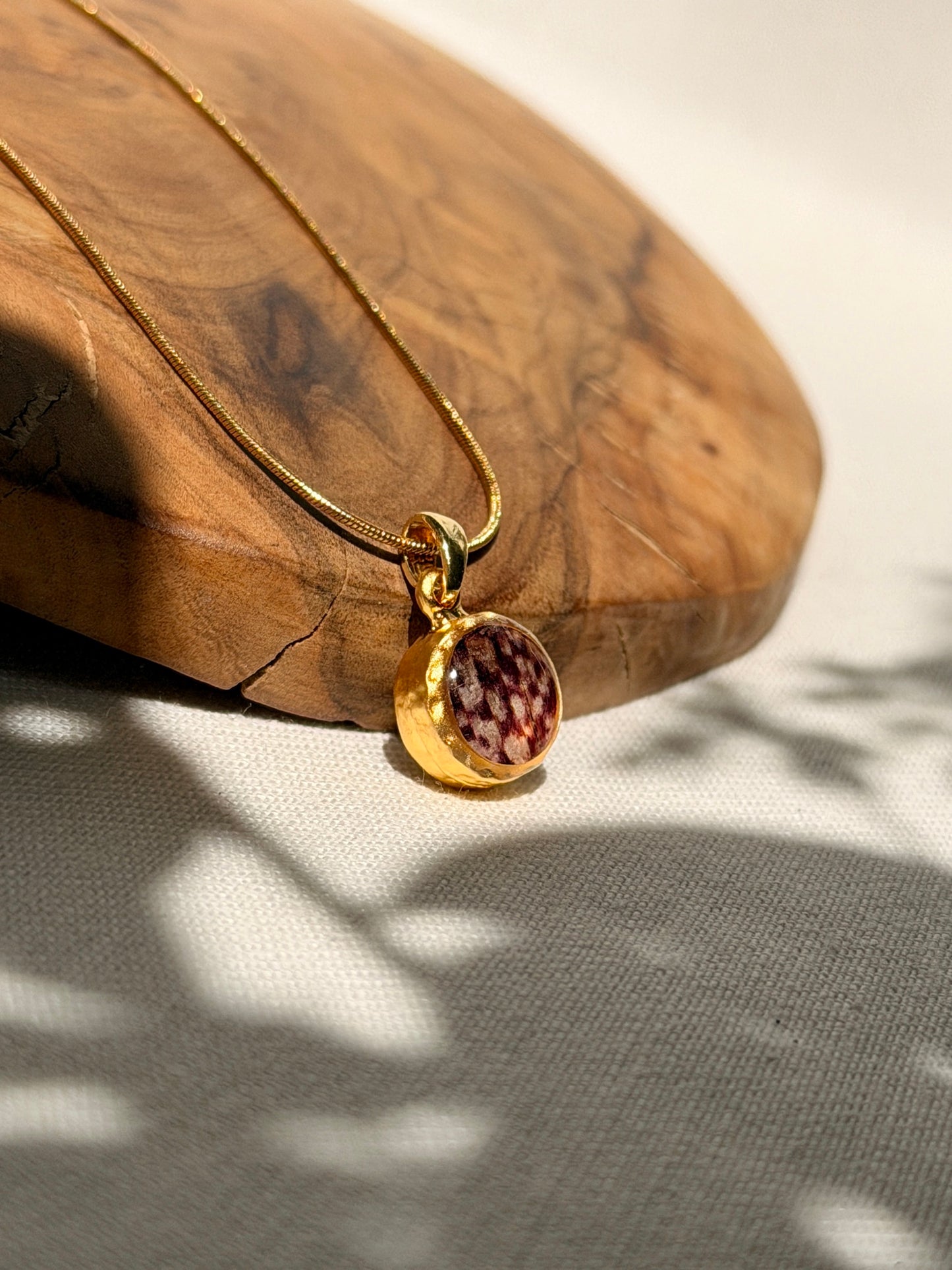 Kleine 22k vergulde hanger met echte kievitsbloem aan een 18k vergulde snake ketting