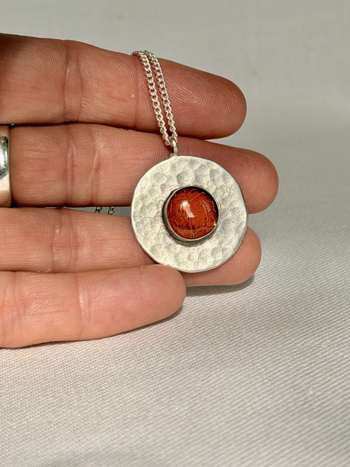 Verzilverde ronde hanger met oranje bloemblad - 25 mm