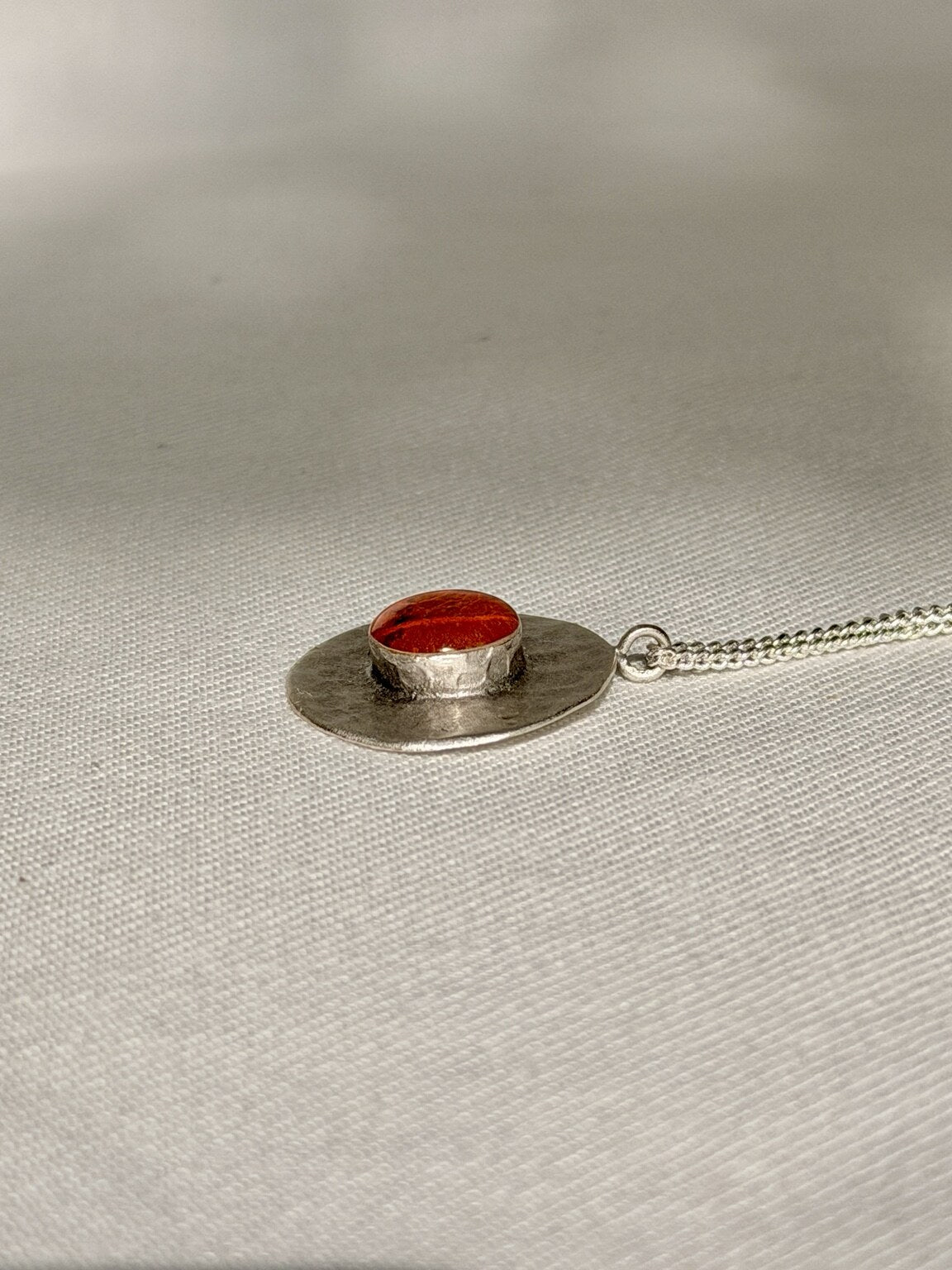 Verzilverde ronde hanger met oranje bloemblad - 25 mm