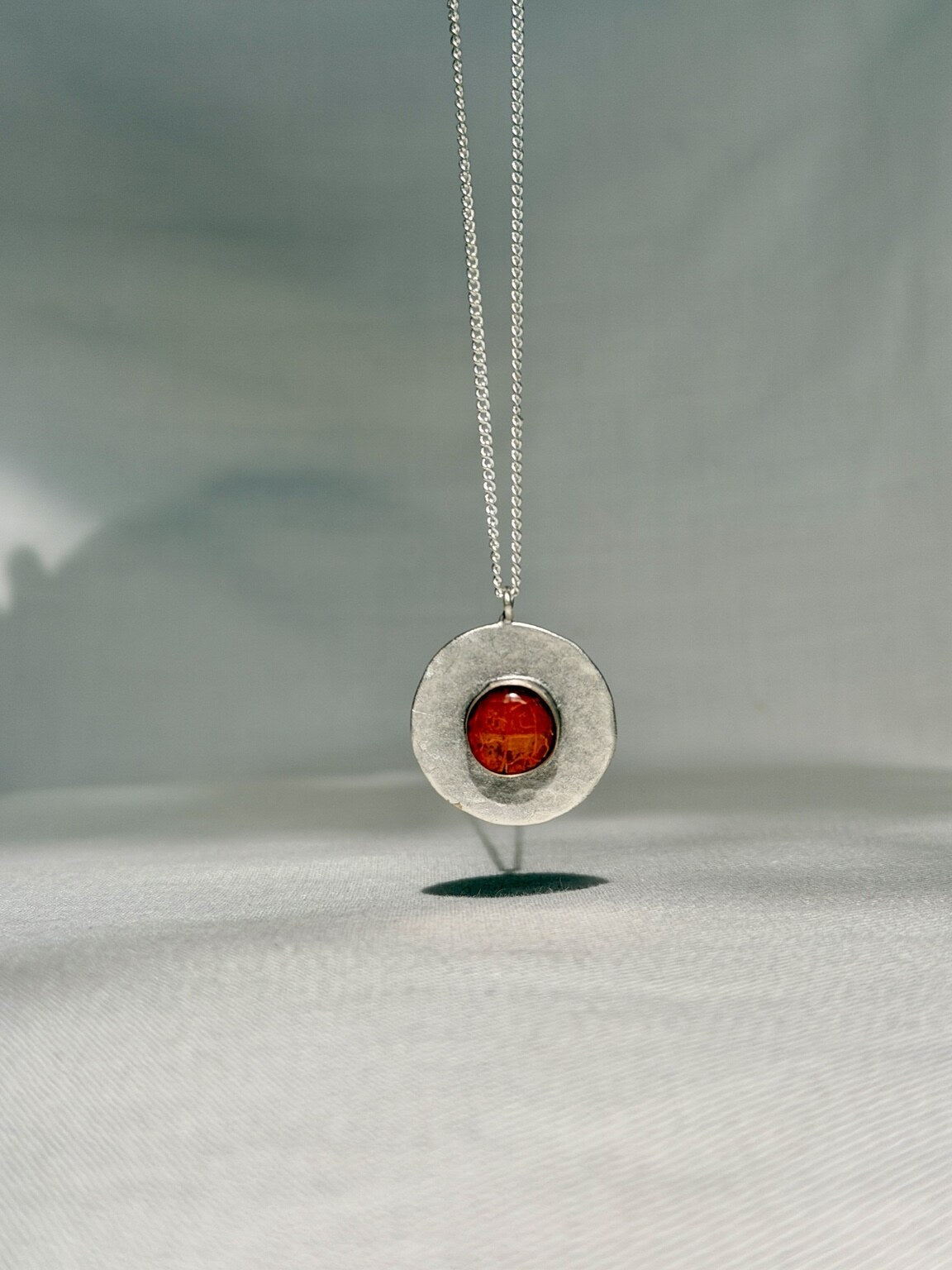 Verzilverde ronde hanger met oranje bloemblad - 25 mm