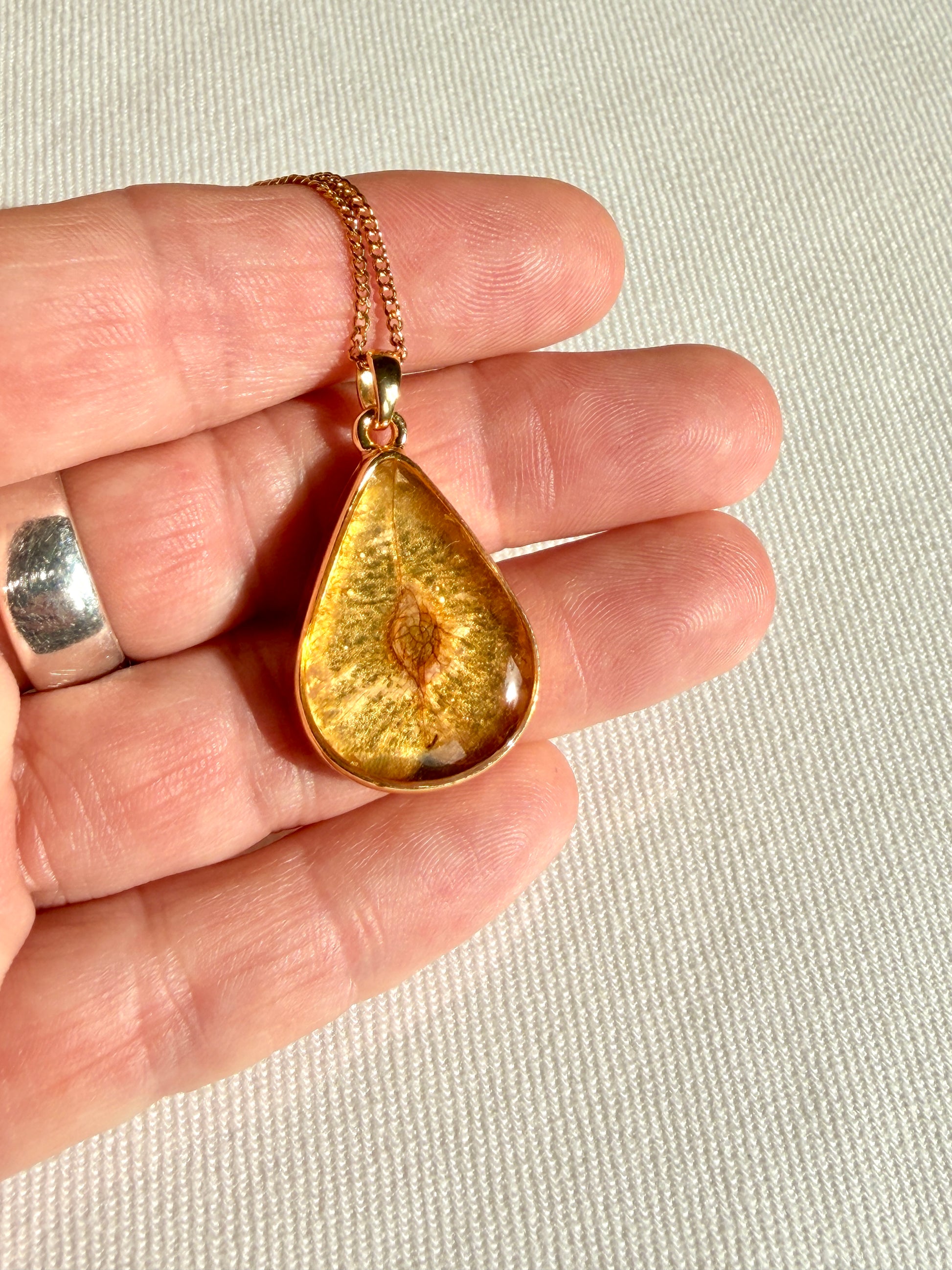 24K vergulde hanger met natuurlijk iepenzaad zichtbaar in transparante resin laag
