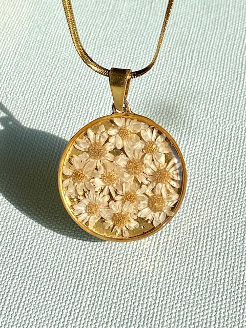 Madeliefjes in een grote ronde hanger, goldplated.