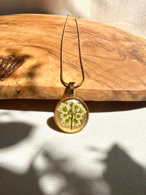 Goudkleurige hanger met echte schermbloem en witte bloemetjes van BeLeaf Art