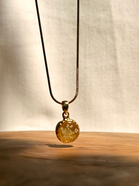 Botanische ketting met schermbloem op zonnebloemblaadje en schermbloem